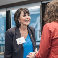 President Mantella smiling and engaged in conversation with woman in orange jacket